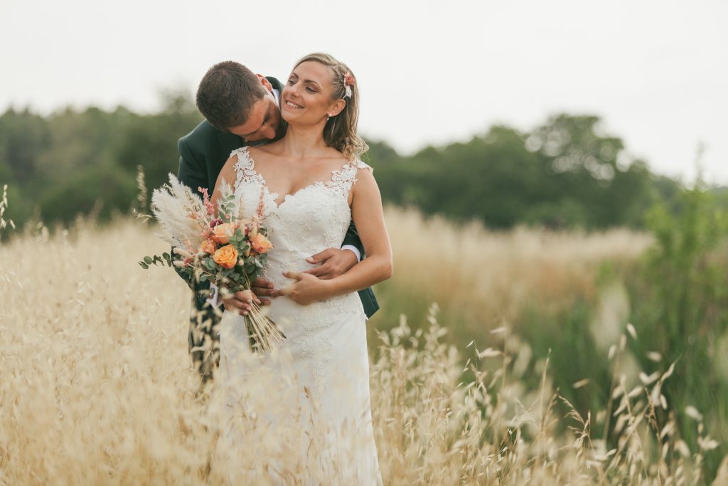 Beau cliché des mariés dans un champs de blé